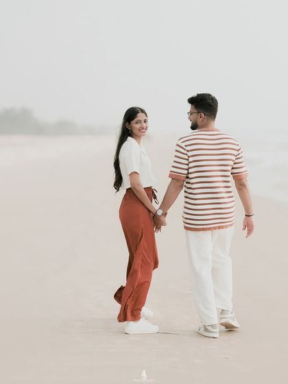 A classic "follow me" shot while walking along the shoreline. This style of photography creates a sense of journey and togetherness, perfect for a pre-wedding album.