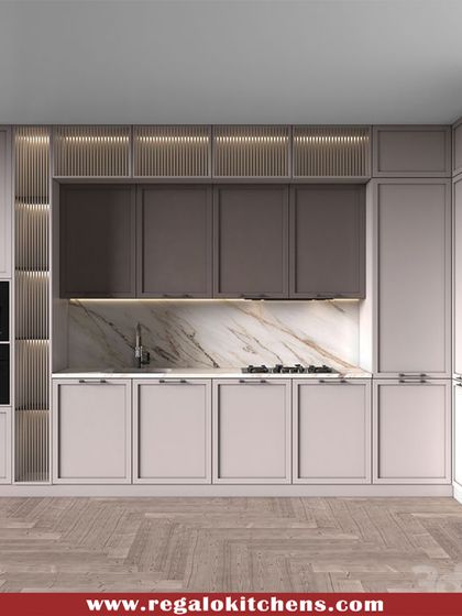 This design combines classic shaker-style cabinets with modern integration. The built-in coffee machine and oven are placed at a convenient height, while the fluted glass details and marble backsplash add layers of texture and elegance.