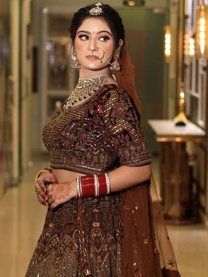 A portrait of the client in her brown velvet lehenga, looking poised and elegant. This outfit is sure to make you feel like royalty at any event.