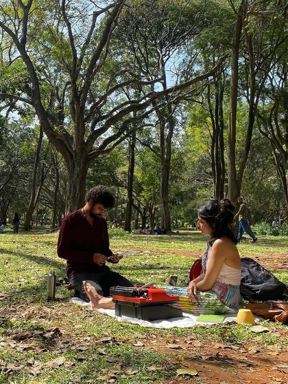 Another perspective of a poetry session in the park. The dappled sunlight, the green grass, the quiet focus. It's a peaceful and profound way to spend an afternoon.