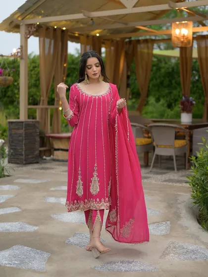 A full-length shot of this elegant pink suit. The client looks graceful and beautiful with her soft, natural makeup.