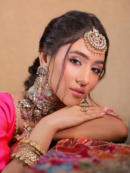 A perfect wedding guest look. This vibrant, multi-colored lehenga is paired with fresh, glowing makeup for a look that is all about elegance and glam.