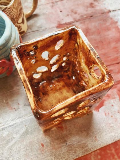 Look at these beautiful little wares from a beginner's course. She created a lovely marbled mug, a textured vase, and a carved luminary with a rich, rustic glaze.