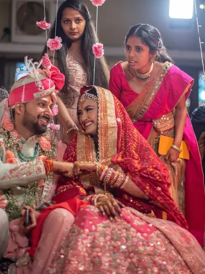 A playful moment during the wedding ceremony, with family looking on.
