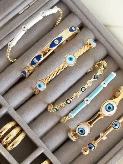 My evil eye bangles are perfect for your go-to stack. This image shows a variety of styles, from the classic white enamel to the twisted gold design.
