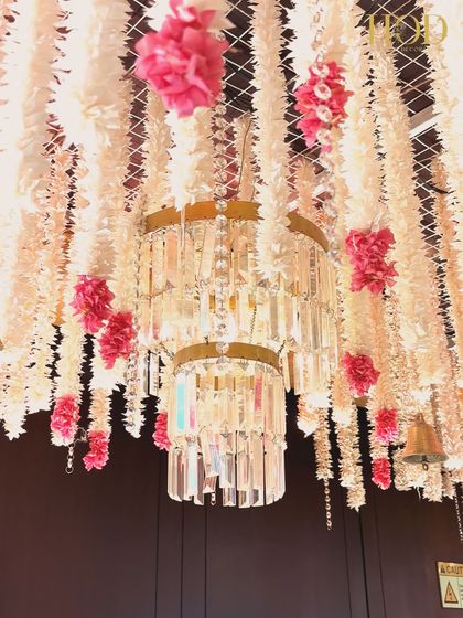 A close-up of a crystal chandelier surrounded by hanging flowers, a perfect example of how I blend lighting and floral elements for a luxurious effect.