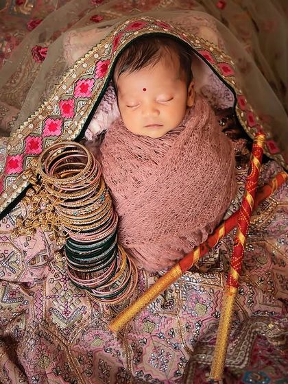Adding symbolic elements like dandiya sticks and bangles, this Navratri-inspired newborn shoot is a wonderful way to honor your family's traditions.