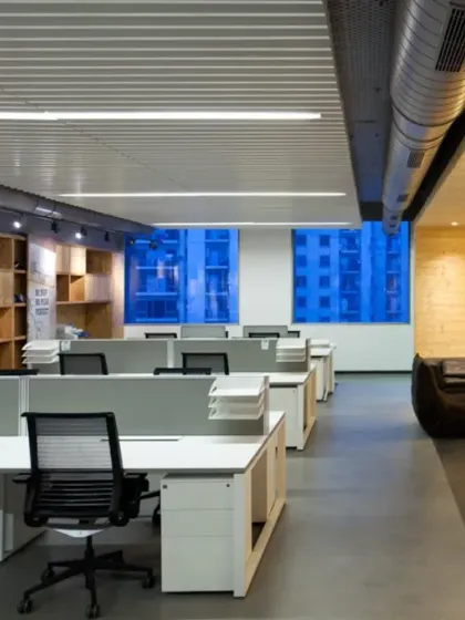 The open workstation area at the Harley-Davidson office is designed for collaboration. The layout is flanked by wooden shelving units and exposed ceiling services, reflecting an industrial aesthetic that is true to the brand.