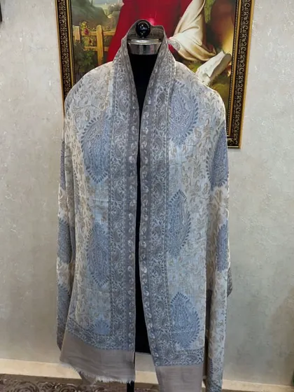 The light blue and grey paisley pashmina, draped to show its beautiful pattern and soft texture.
