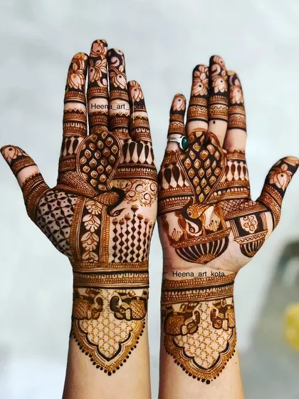 A traditional Rajasthani design with peacock and elephant motifs. The palms are fully covered with different intricate patterns, showcasing a classic bridal style.