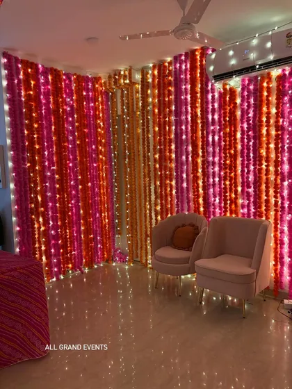 A close-up of the marigold and fairy light wall, showing the beautiful texture and vibrant colors. This type of backdrop is perfect for guest photos.