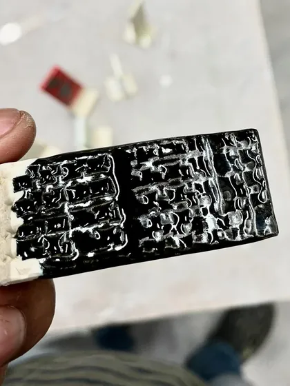 Glaze testing is a science and an art. This test tile shows a beautiful, textured black glaze. Each test reveals a new possibility.