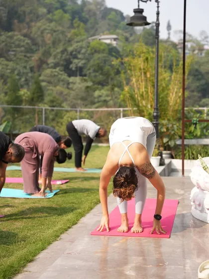 A group of us in Uttanasana (Standing Forward Fold) during an outdoor practice. Folding forward is an act of surrender and release.