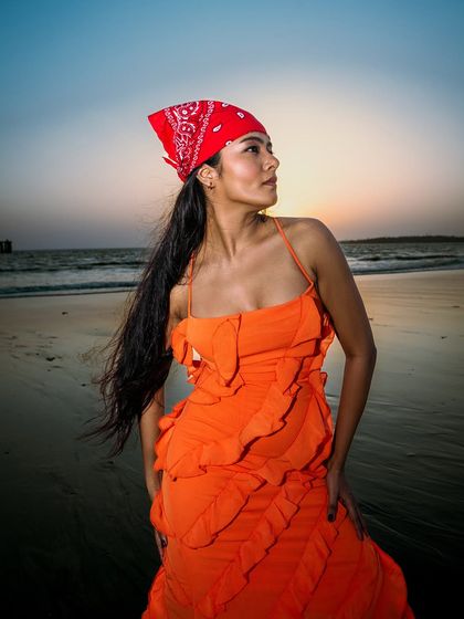 A beautiful portrait of the model looking out at the sea as the sun sets. The colors of the sky and the dress are in perfect harmony.