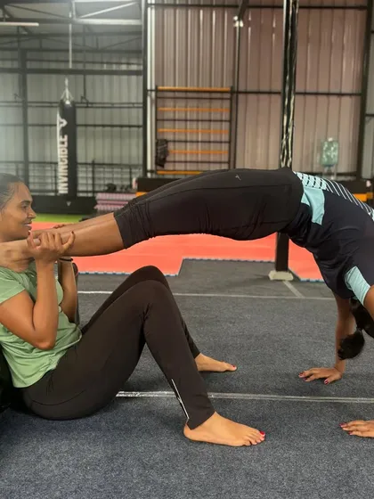 A partner-assisted backbend helps this student safely deepen her stretch and improve flexibility.