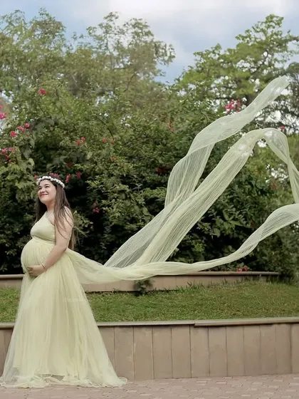 An outdoor shot that captures movement and drama, with the long train of a green gown flowing in the breeze.