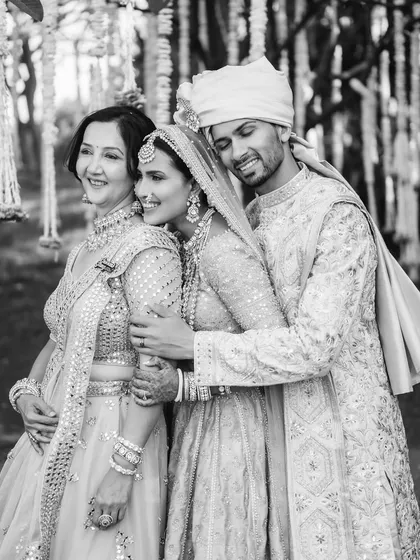 A touching black and white photo of a groom embracing his bride and her mother. This image beautifully captures the joining of two families and the deep emotional bonds shared on a wedding day.