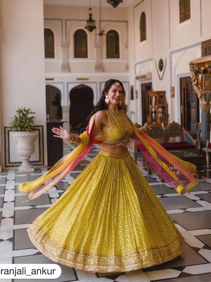 A bride twirling in her beautiful yellow lehenga. We help our clients feel confident and radiant, so they can enjoy every moment of their celebration, both on and off the dance floor.
