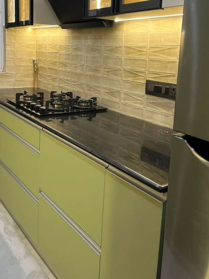 This handle-less design with G-profile channels gives the kitchen a clean, seamless look. The black granite countertop provides a durable and practical workspace.