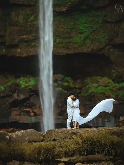 An epic moment captured against a majestic waterfall, with the fabric of the dress catching the wind. This is the kind of grand, cinematic shot we love to create, turning your love story into a breathtaking visual. We specialize in destination pre-wedding photography that makes a statement.