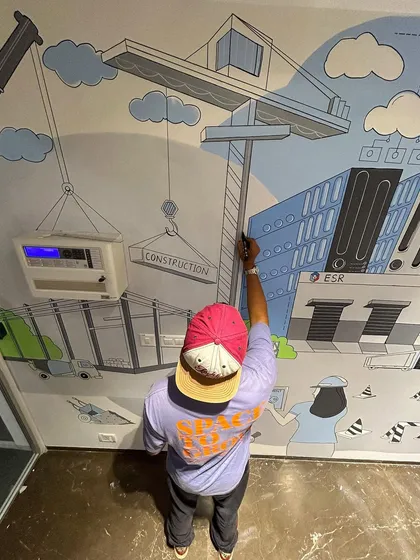 Here I am adding the final black outlines to the construction crane element of the ESR office mural. This piece involved illustrating various aspects of the industrial and logistics real estate sector.