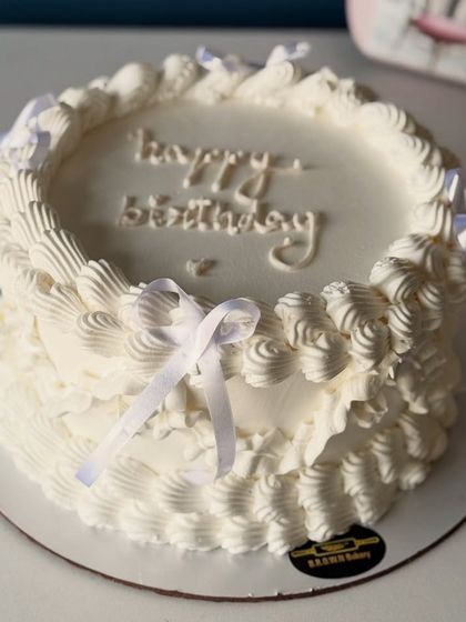 Our popular chocolate truffle cake, decorated in a classic vintage style with intricate white buttercream piping and delicate ribbon bows. It’s proof that even a simple flavor can be dressed up for a fancy occasion.