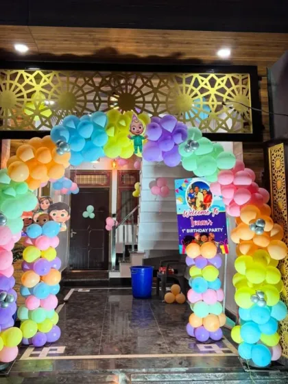 A vibrant Cocomelon themed entrance arch to welcome guests to the party. The multi-colored balloon arch is decorated with character cutouts, setting a fun tone from the start.