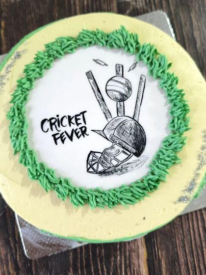 A cake for a cricket fanatic. I hand-sketched the helmet, ball, and wickets using black food coloring on an edible sheet for a clean and artistic look.