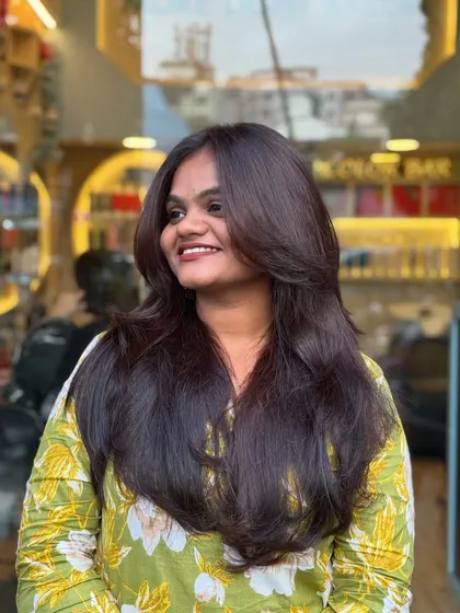 A happy client showing off her new soft layers. This haircut is perfect for adding volume and making the hair feel lighter and more dynamic.