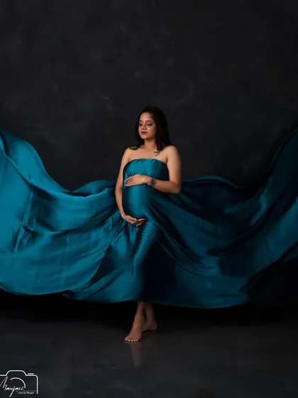 The fabric toss creates a beautiful frame around the mother, making this a truly captivating and dramatic studio portrait.