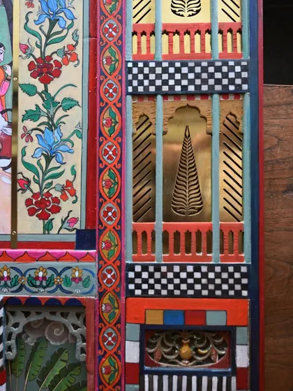 A detail shot showing the new brass insert alongside the vibrant, hand-painted borders and floral patterns. The mix of materials and textures is what brings the piece to life.