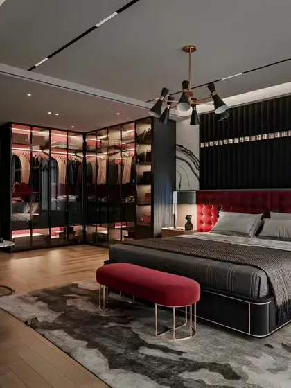 I designed this master bedroom to feel like a luxury suite, featuring a custom tufted red headboard and a statement walk-in wardrobe. The wardrobe has a sleek, dark frame with smoked glass doors and internal lighting to elegantly display the clothing collection.