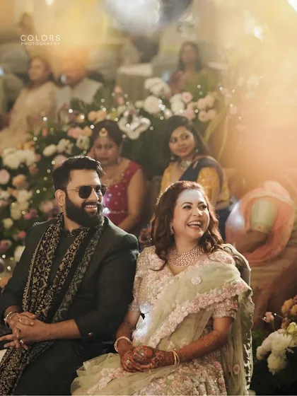 A beautifully lit candid photo of the couple at their reception, sharing a happy moment.