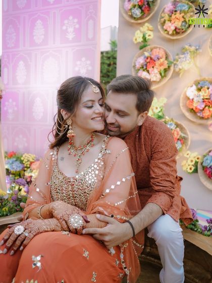 An intimate moment between the couple at their Haldi, seated amidst a beautiful floral setup.