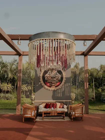 A standalone lounge seating setup under a grand floral chandelier, creating an intimate and luxurious conversation spot within a larger event space.