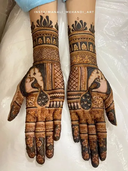 A bold and elegant engagement mehandi featuring symmetrical peacock motifs. The design combines traditional Indian patterns with negative space to create a striking look.