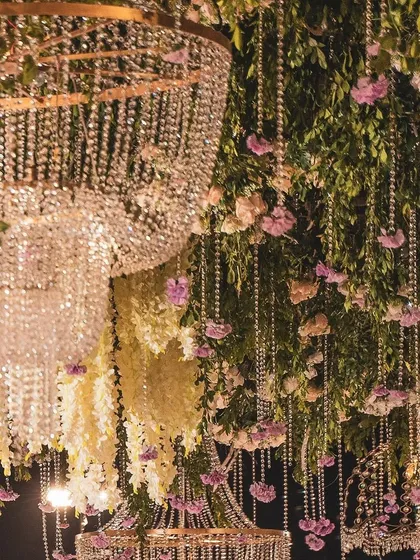The magic is in the details. This close-up shows the intricate layering of cascading crystal strings, fresh wisteria, and delicate pink flowers that formed a part of a magnificent hanging installation, adding depth and luxury to the event's overall design.