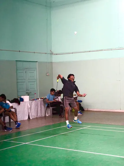 A player follows through on a smash, demonstrating the proper technique and body rotation after making contact with the shuttle.