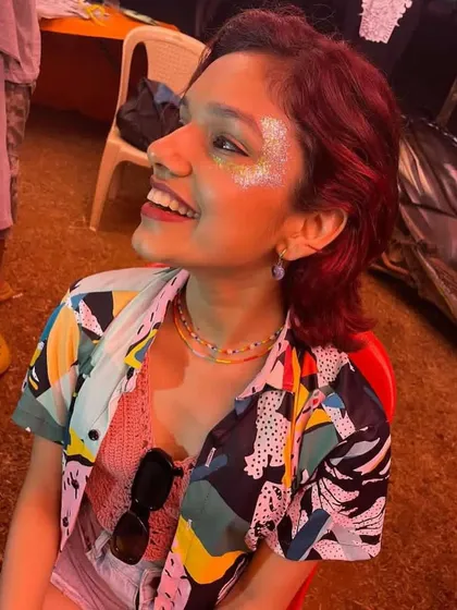 A happy client at Sunburn festival with a scattered iridescent glitter look. The pure joy on her face says it all.
