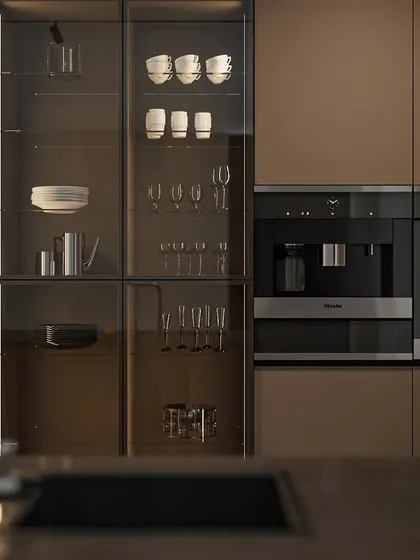 The tall unit integrates a coffee machine, oven, and a glass-fronted display for crockery. This is a great example of how I design dedicated zones for different kitchen activities.