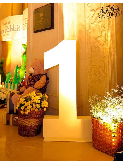 A large, illuminated number '1' next to a Peter Rabbit backdrop, marking the special milestone of the first birthday.