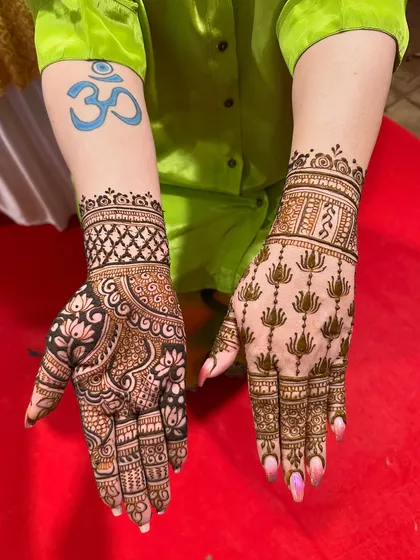 A close-up of two distinct mehndi styles on one client. The contrast between the heavy, dark floral design and the lighter lotus pattern is stunning.