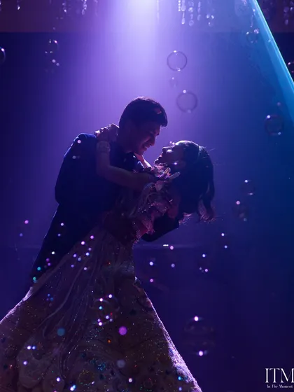 A magical first dance surrounded by bubbles and a dreamy purple light. This is a candid moment of pure romance and happiness, captured as the couple shares a dance at their reception.