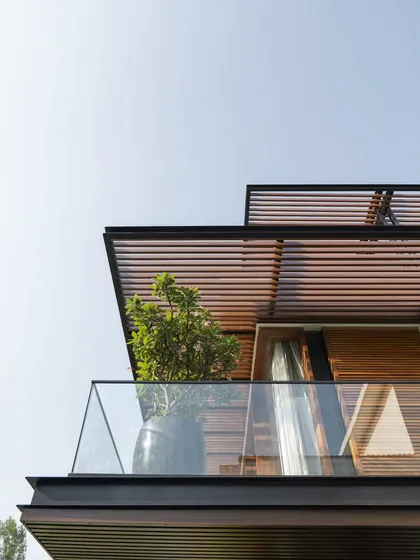This upward-looking shot captures the floating, lightweight quality of the new pergolas and balcony. The design transforms the home's profile, giving it a distinctly modern and airy character.