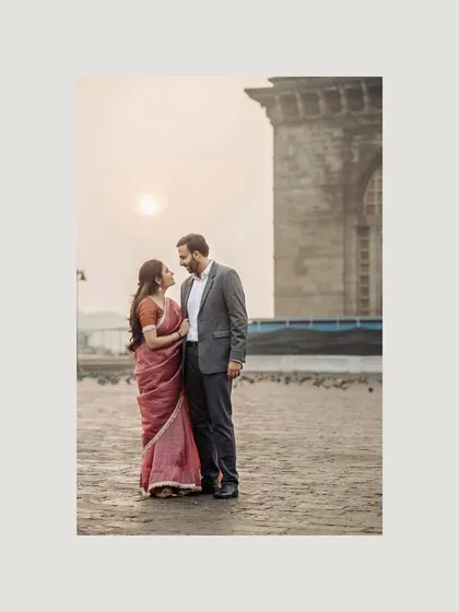 A full-length portrait at the Gateway of India as the sun begins to rise. The soft light and serene mood make for a beautifully romantic photograph.