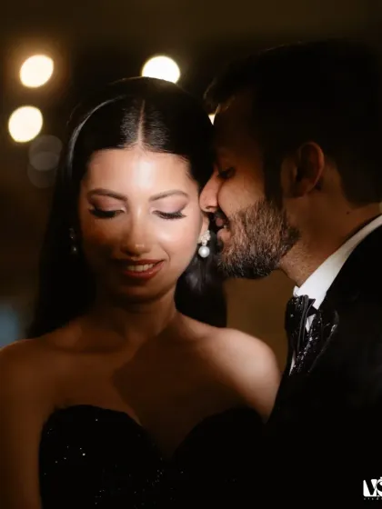 A close-up, intimate moment between the couple during their cocktail party. The soft lighting and their gentle expressions create a romantic and heartfelt image amidst the celebration.