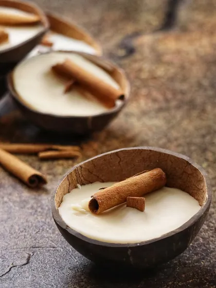 My Cinnamon Coconut Soy Candle, poured in a natural coconut shell with a real cinnamon stick, designed to evoke warm, nostalgic memories.