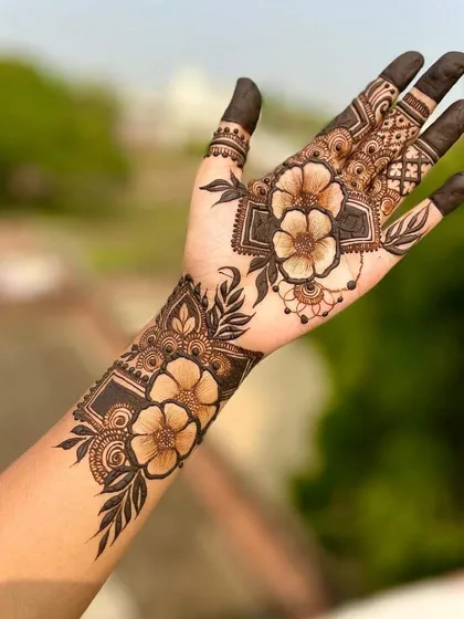 A stunning shaded floral design. The bold flowers on the wrist and palm are the centerpiece, showcasing advanced shading techniques that create a 3D effect.