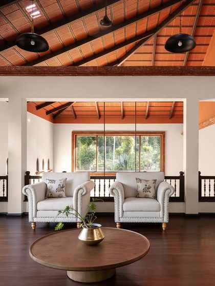 The living area of the Dream Coffee Estate is defined by its soaring terracotta roof and views into the mezzanine lounge above. The space is designed to feel open and connected, with natural light and earthy materials creating a calm, grounded atmosphere for family life.