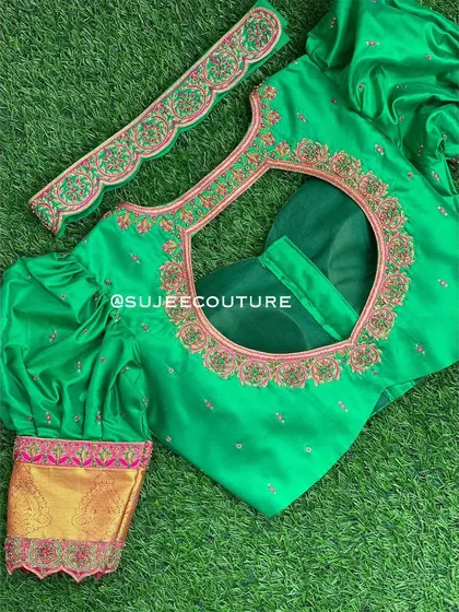 A bright green blouse with dramatic puff sleeves. The back features a large circular cutout framed with pink and gold embroidery, and the cuffs are made of contrasting brocade fabric.